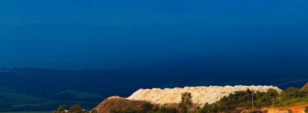 panoramic view of a stone mine in Sao Thome, contrasting with a sky darkened by an approaching storm - Sao Thome das Letras, MG, BRAZIL.