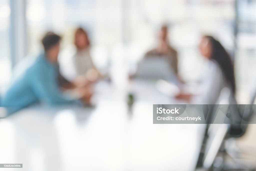 Defocussed image of Business people during a meeting. Defocussed image of Business people during a meeting. They are sitting in a board room, All are casually dressed. Defocused Stock Photo