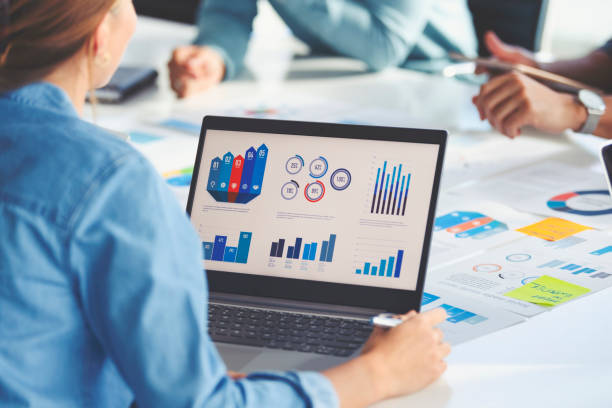Multi racial group of people working with Paperwork on a board room table at a business presentation or seminar.