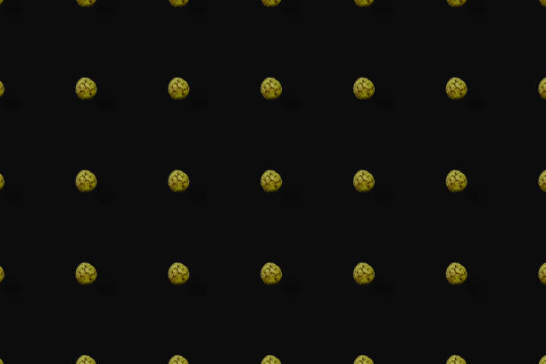 istock Colorful fruit pattern of fresh cherimoya on black background. Custard apple. Top view. Flat lay. Pop art design 1368261199