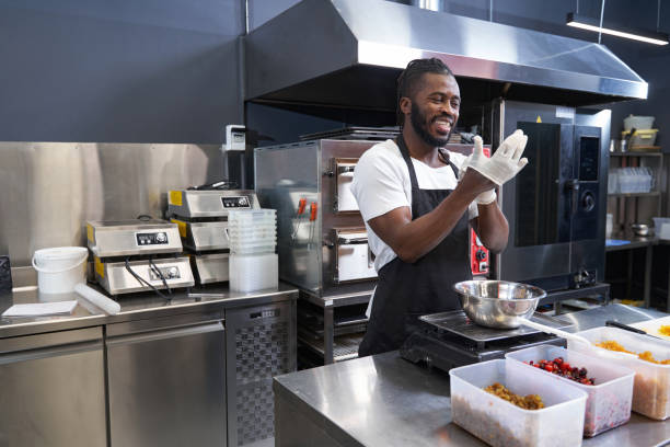 istock Smiling american man working at the kitchen 1368263239