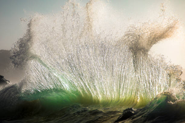 fotograma completo de la ola que explota en el cielo a la luz del sol brillante - spraying beaches summer sunlight fotografías e imágenes de stock