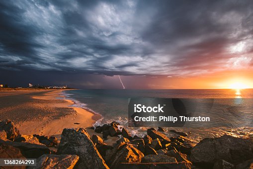 istock Incredible beach sunset during lightning storm beneath dark dramatic clouds 1368264293