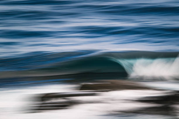 Long exposure of teal blue barreling wave