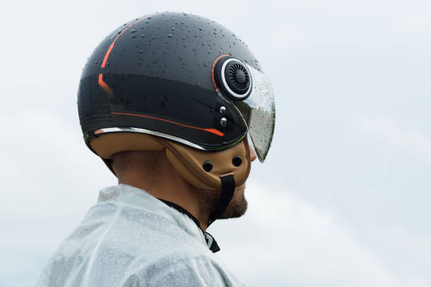 istock Biker in helmet and raincoating on a rainy cloudy day. 1368264478