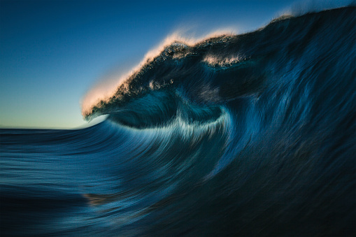 Perfect deep blue ocean wave breaking into the sea