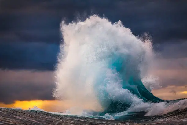 Photo of Powerful wave exploding into sky during multi colored sunset