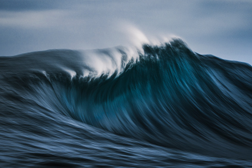 Slow shutter of deep blue ocean wave in motion