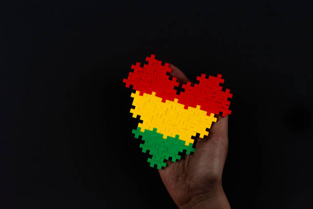 Black History Month background. African American history month celebration. Hand holding heart in red, yellow, green colors flag over black background stock photo