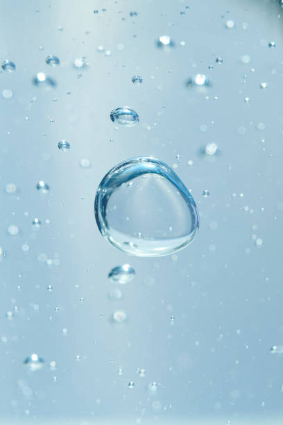 Bubbles of air or oxygen in water or gel. Can also represent a molecule or oil particle in a transparent liquid. Round and blue floating bubbles similar to hyaluronic acid. Shallow depth of field. frothy drink stock pictures, royalty-free photos & images