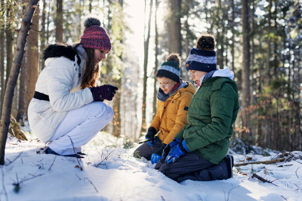 istock Three kids hiking in beautiful winter forest on a sunny day 1368272451