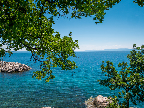 Blue and green sea, beautiful beach and green trees in Kostrena, Croatia.