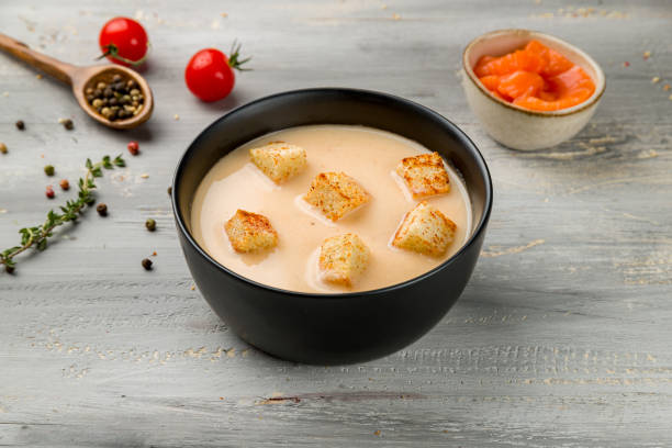 salmon cream soup on black bowl on grey wooden table