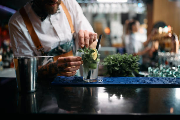 istock Close-up of bartender preparing mojito cocktail at bar counter. 1368278205
