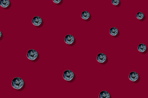 istock Colorful fruit pattern of fresh blueberries on red background. Top view. Flat lay. Pop art design 1368278374