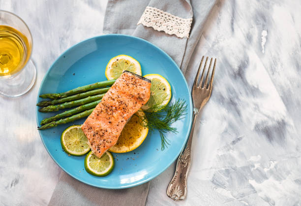 Grilled fillet of salmon with asparagus served on a plate Grilled fillet of salmon with asparagus and glass of white wine grilled salmon stock pictures, royalty-free photos & images