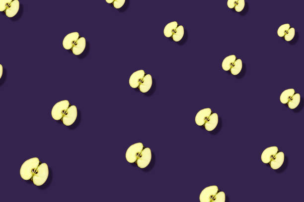 istock Colorful fruit pattern of fresh apples sliced on violet background. Top view. Flat lay. Pop art design, creative summer concept 1368280344