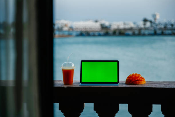 istock Tablet with green screen on balcony with seaview 1368281359
