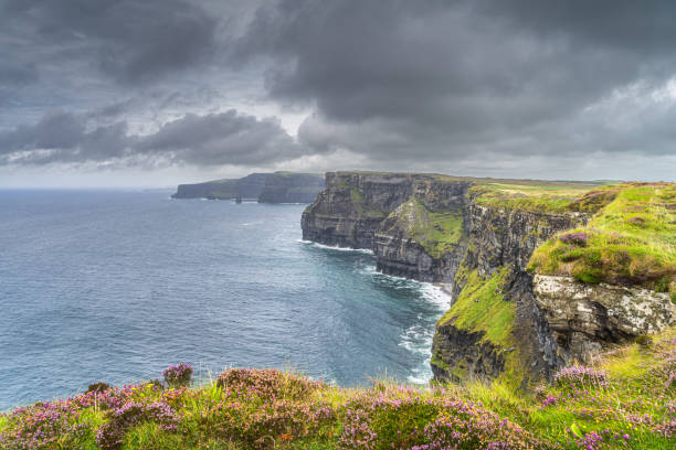 Dark, dramatic storm sky over iconic Cliffs of Moher, popular tourist attraction, UNESCO world heritage, Wild Atlantic Way, Clare, Ireland