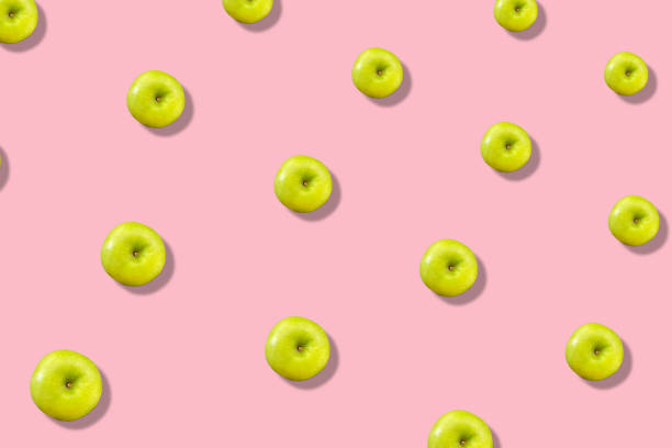istock Colorful fruit pattern of fresh green apples on pink background with shadow. Top view. Flat lay. Pop art design, creative summer concept 1368285043