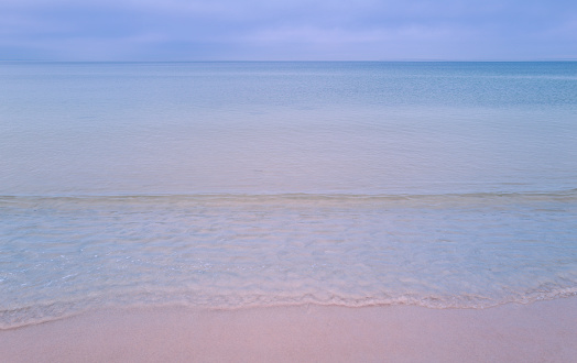 Soft blue ocean wave on clean sandy beach. Bangka Island, Indonesia.