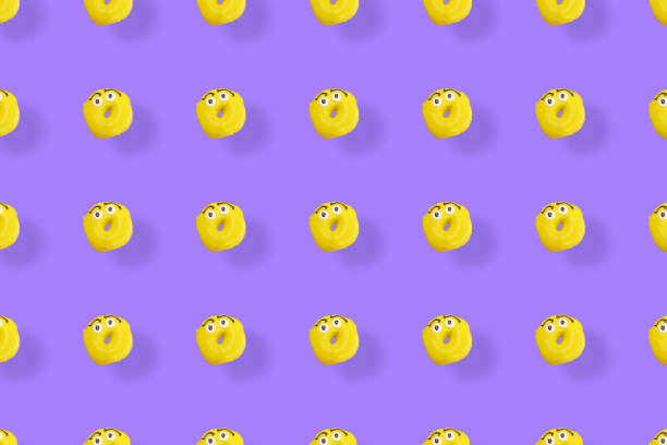 istock Colorful pattern of yellow glazed donuts isolated on purple background with shadows. Doughnuts. Top view. Flat lay 1368287197