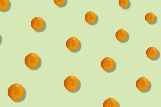 istock Colorful fruit pattern of fresh orange on light yellow background with shadows. Top view. Flat lay. Pop art design 1368288151