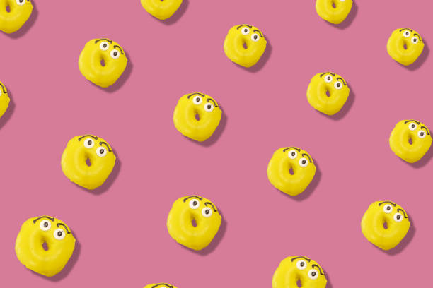 istock Colorful pattern of yellow glazed donuts isolated on pink background with shadows. Doughnuts. Top view. Flat lay 1368288943