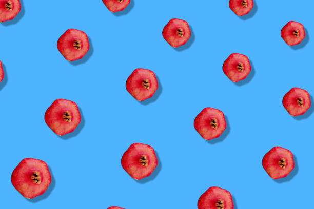 istock Colorful fruit pattern of fresh pomegranates on blue background. Top view. Flat lay. Pop art design 1368290193