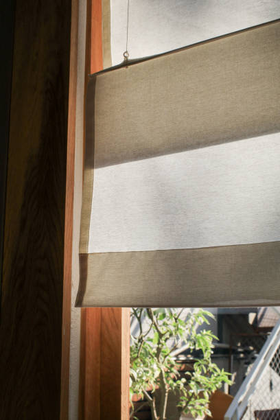 istock Cream curtains made of dense fabric with soft shadow. Textured abstract backgrounds with sunlight through the window. 1368293440