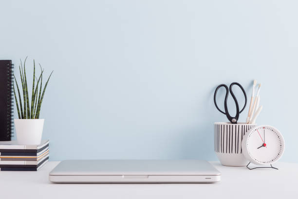 istock Mock up laptop, notebook on young student desk against blue wall. Back to school mock up. 1368296653