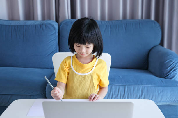 istock little asian girl student study online using laptop computer at home 1368296878
