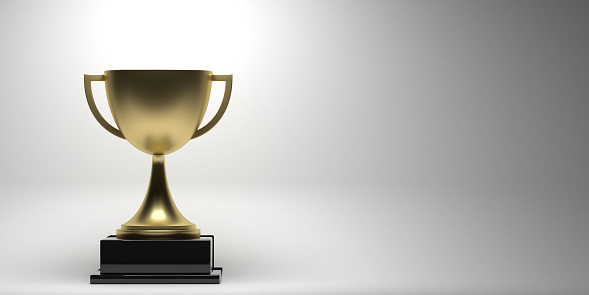 A trophy held aloft in front of black background