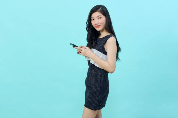istock young woman standing and using cell phone 1368300619