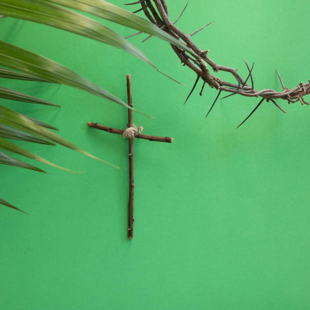 istock Cross, palms and crown of thorns on green 1368304149