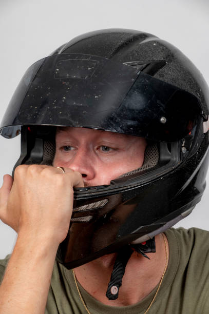istock Young man buckles his motorbike helmet. 1368307059