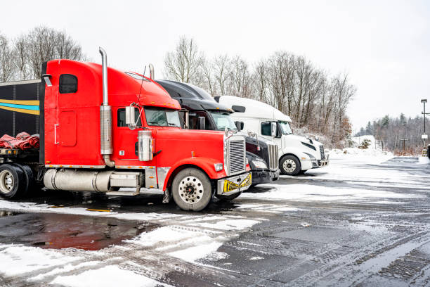 red and white semi-trucks parked on a snowy parking lot