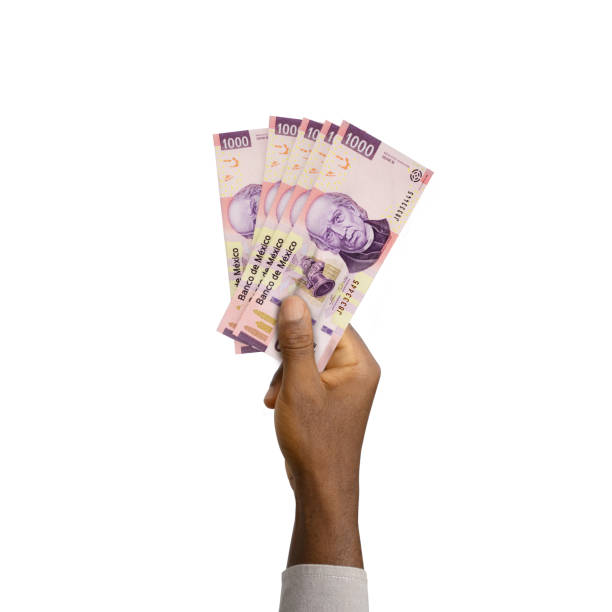 istock Black Hand holding 3D rendered 1000 Mexican peso notes isolated on white background 1368314909
