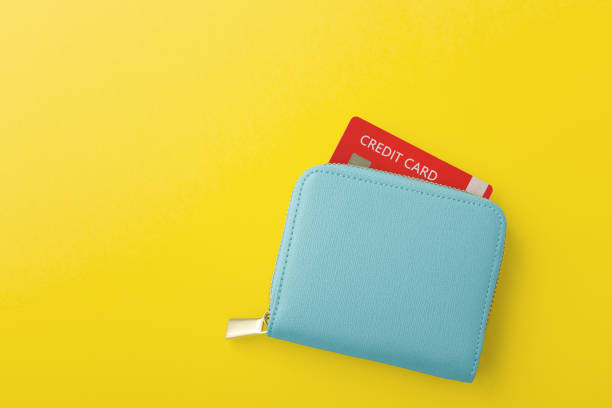 istock Credit card in blue wallet on yellow background 1368318712