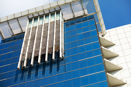 View up blue colored glassy fensterfront of modern office building in Bangkok Chatuchak