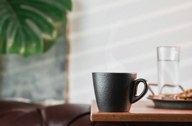 Espresso, close-up, steam rises above the mug. Close-up, selective focus with copy space. Aromatic Italian coffee for breakfast in a cafe.