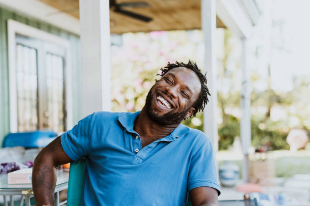 hombre negro en momento alegre riendo al aire libre - polo shirt african ethnicity men african descent fotografías e imágenes de stock