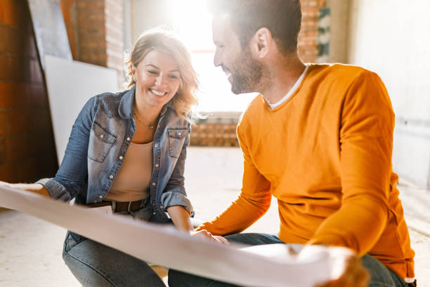 istock Happy couple analyzing plans at their renovating apartment. 1368329324