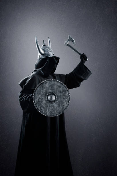istock Warrior with horned helmet, axe and round shield in the dark 1368329395