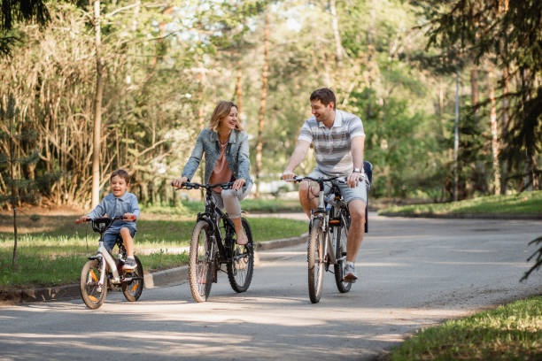 istock Happy family having bicycle ride in park together 1368329704