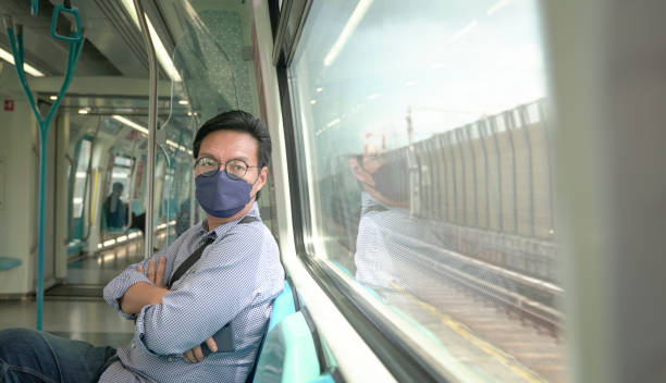 istock Man commuter with face mask on inside a moving subway train. 1368330481