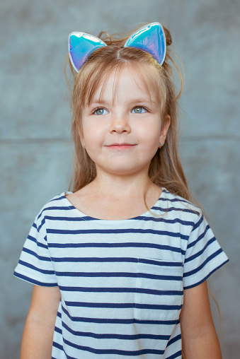 caucasian adorable cute sweet little girl with long blonde hair in striped t-shirt and cat's ears