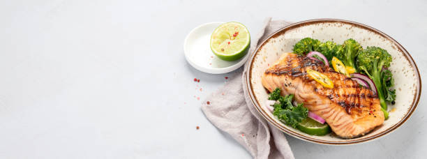 istock Baked salmon with vegetables on light background. 1368331827