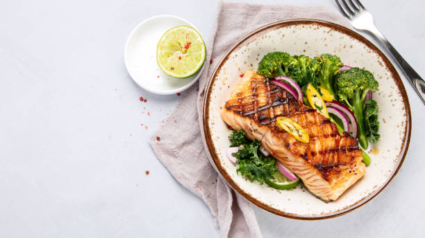 istock Baked salmon with vegetables on light background. 1368331870
