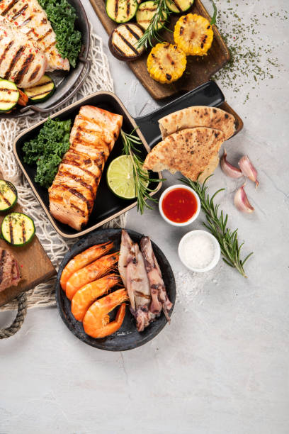 istock Grilled fish, seafood and meat assortment on light background. 1368332721